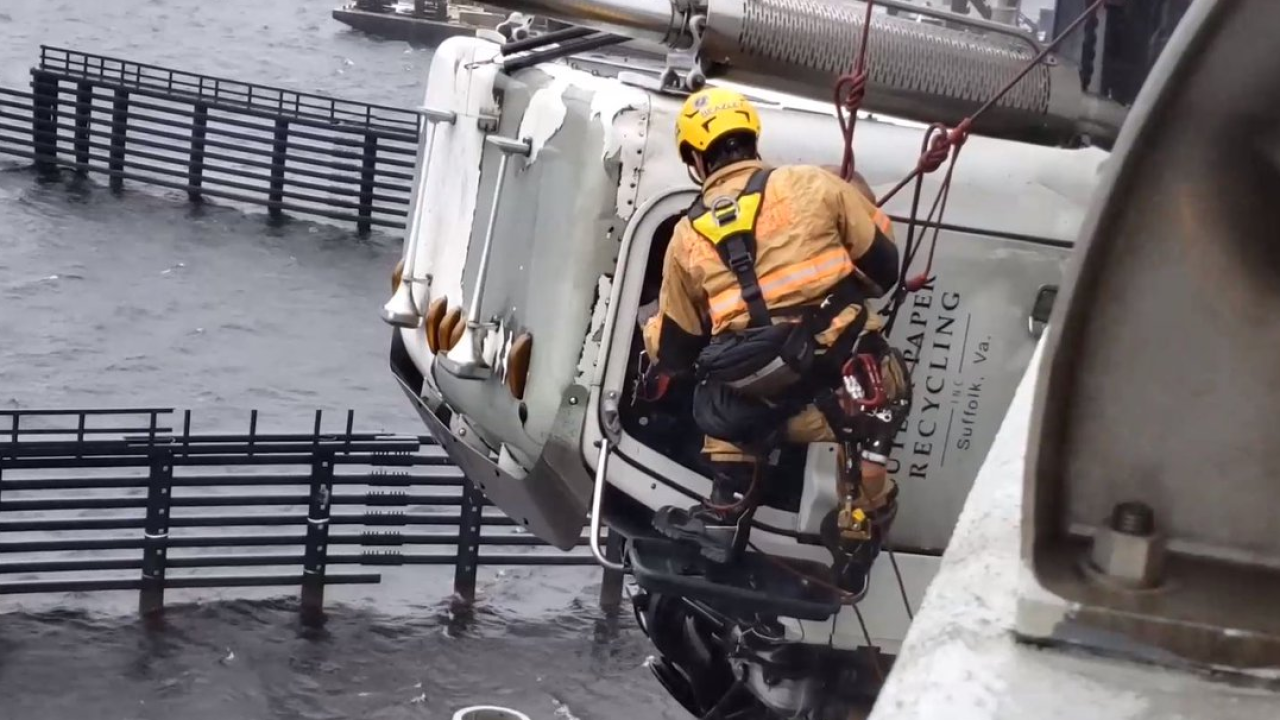 Tractor trailer cab partially hanging off side of High Rise Bridge after accident