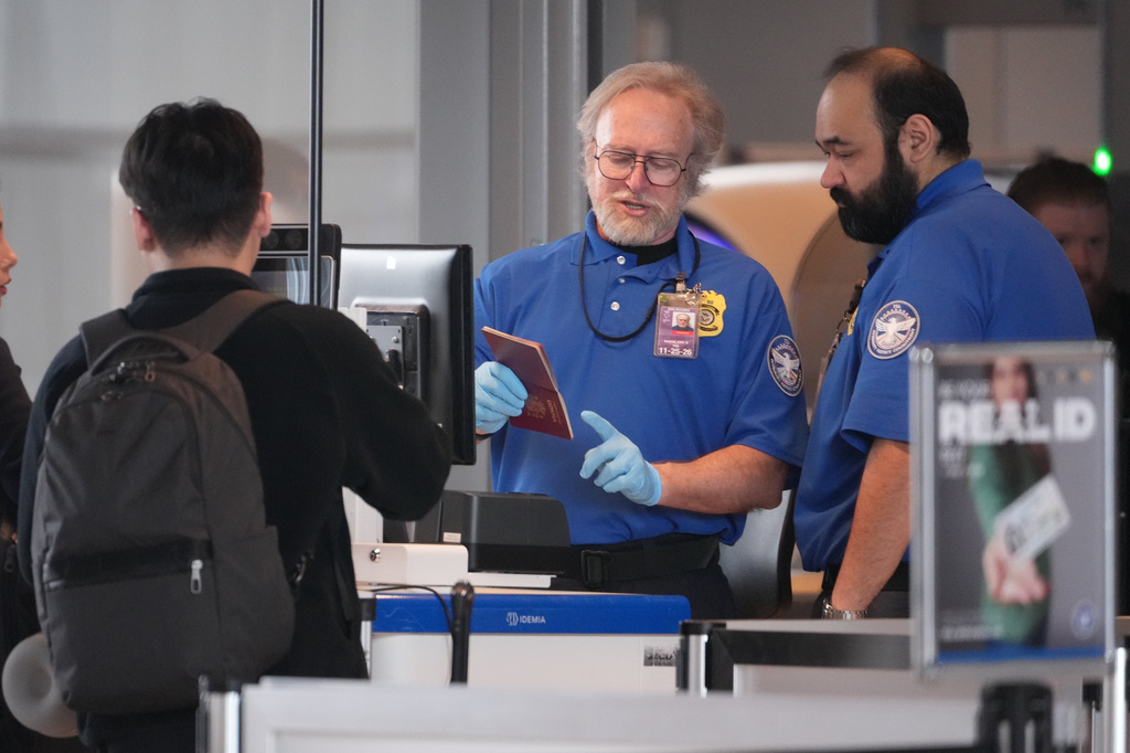 TSA workers check a passenger's passport at Greater Pittsburgh International Airport in Imperial, Pa., on Thursday, March 26, 2026.