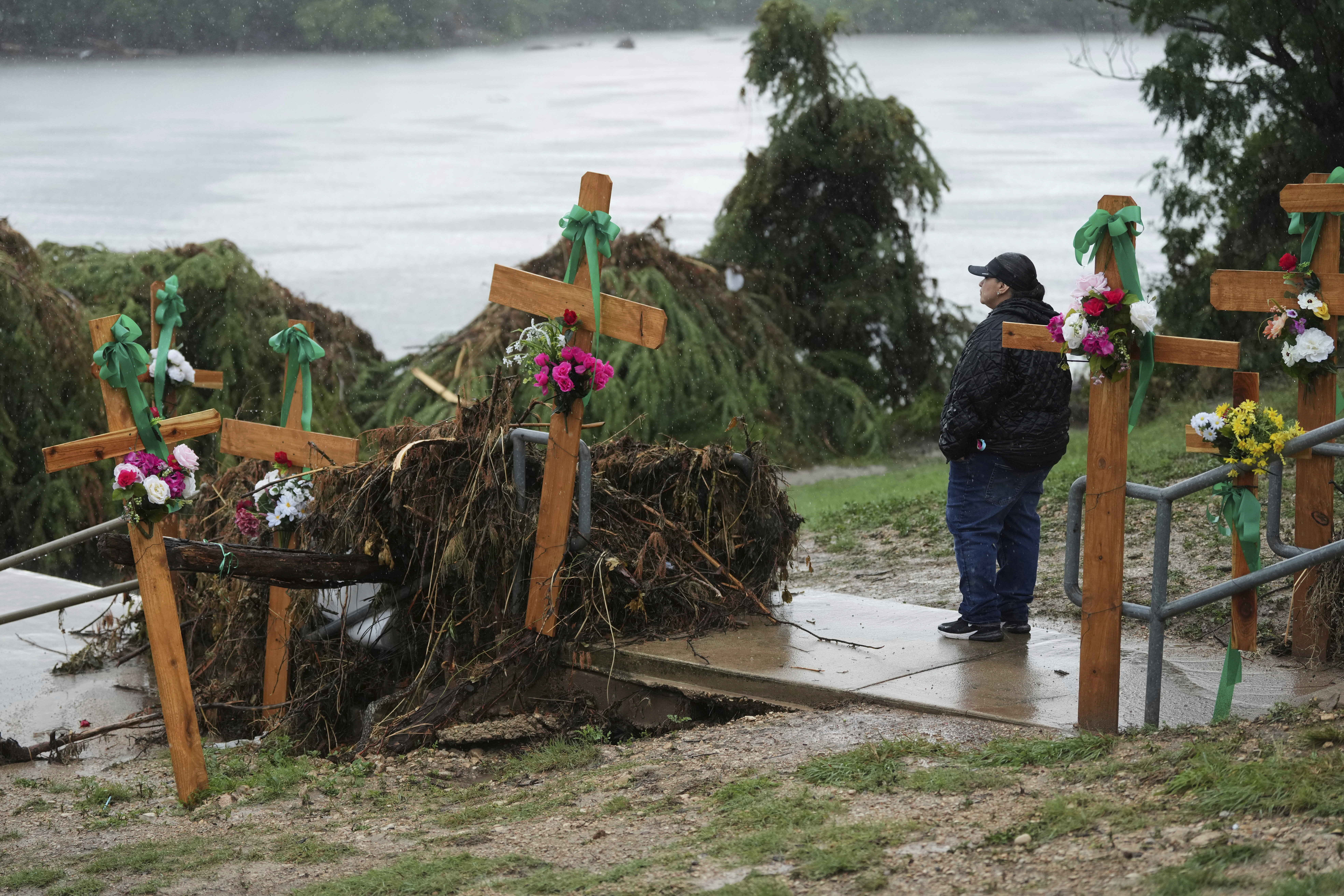 Rain falls as Irene Valdez visits a make-shift memorial for flood victims along the Guadalupe River, Sunday, July 13, 2025, in Kerrville, Texas. 