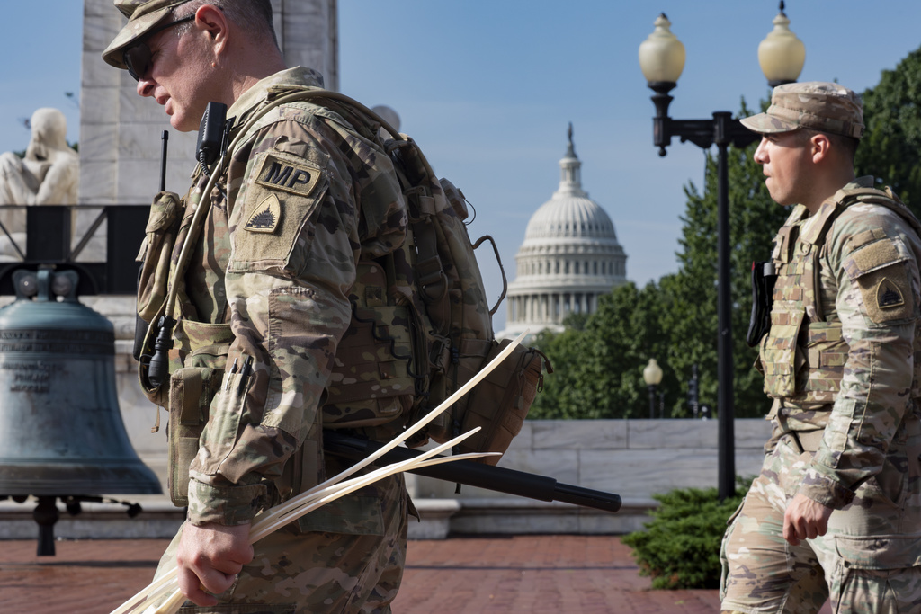 National Guard personnel keep watch as travelers arrive at the entrance to Union Station near the Capitol in Washington.