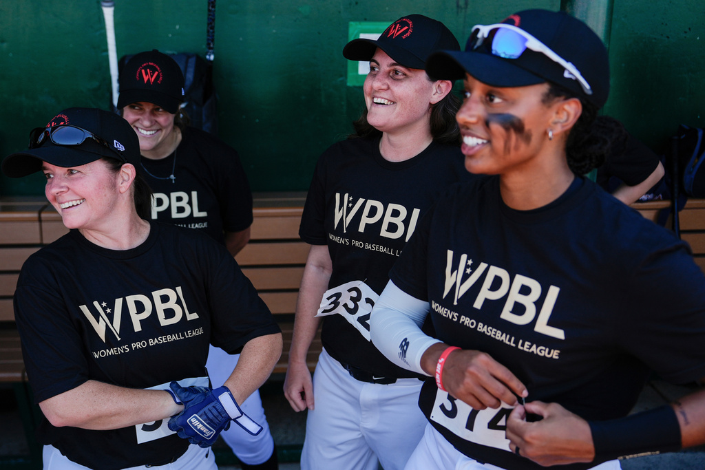 Lauren Boden, second from right, Stephanie Everett, right, and other players talk in the dugout during the first day of tryouts for the Women's Professional Baseball League.