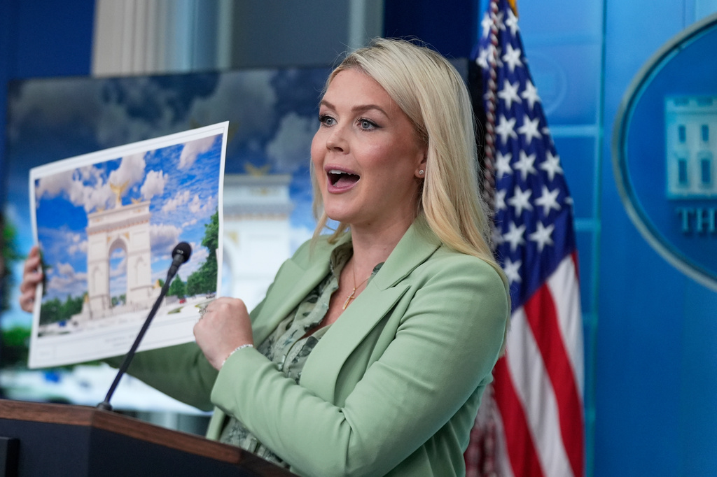 White House press secretary Karoline Leavitt holds up an artist rendering of the new triumphal arch as she speaks with reporters in the James Brady Press Briefing Room at the White House, Wednesday, April 15, 2026, in Washington. 