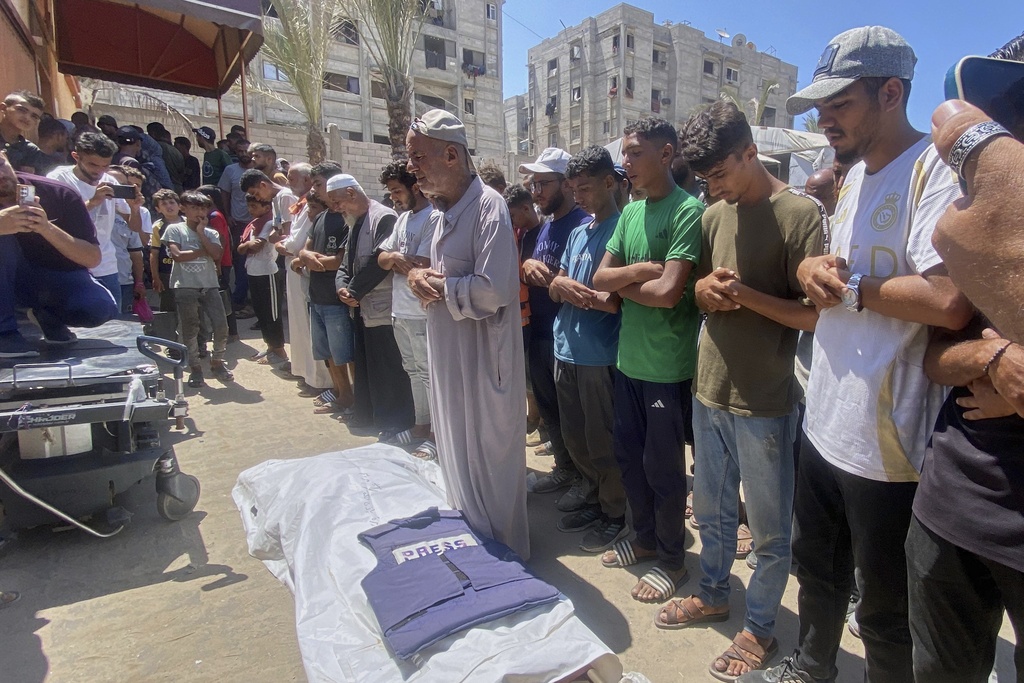 In this family handout photo, Riyad Dagga, center, and other relatives and friends pray over the body of his daughter, freelance journalist Mariam Dagga, 33, during her funeral after she was killed in a double Israeli strike on Nasser Hospital in Khan Younis, southern Gaza Strip.