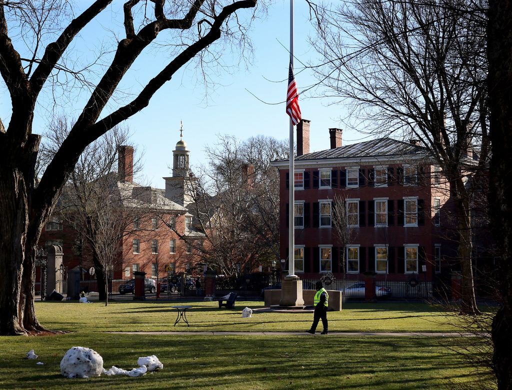 A security guard walks past a flag at half-staff on the main green of Brown University in Providence, RI, Thursday, Dec. 18, 2025.