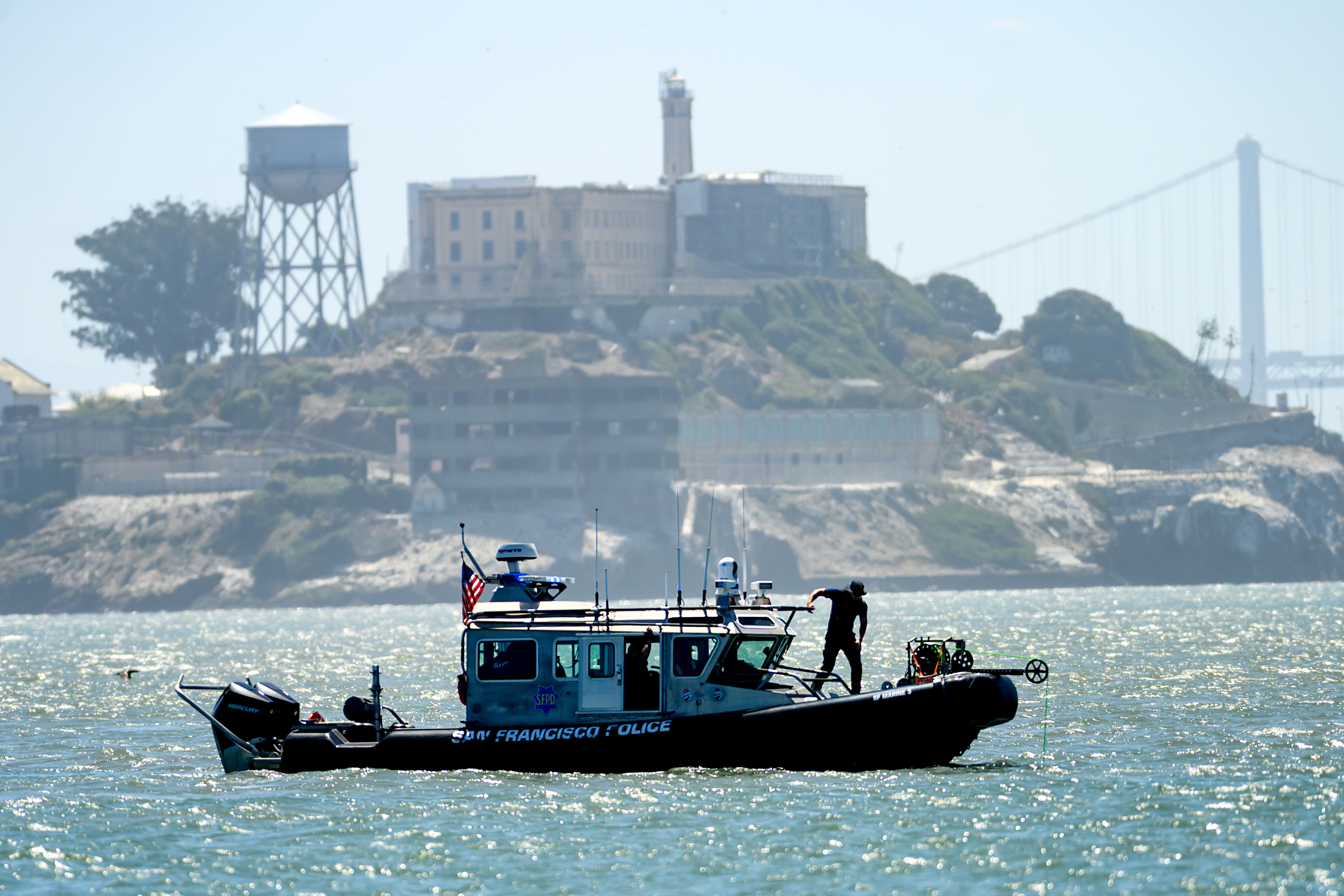 A police boat passes Alcatraz Island as search and rescue operations continue for victims of a Tuesday boat sinking on Wednesday, July 15, 2026, in San Francisco.