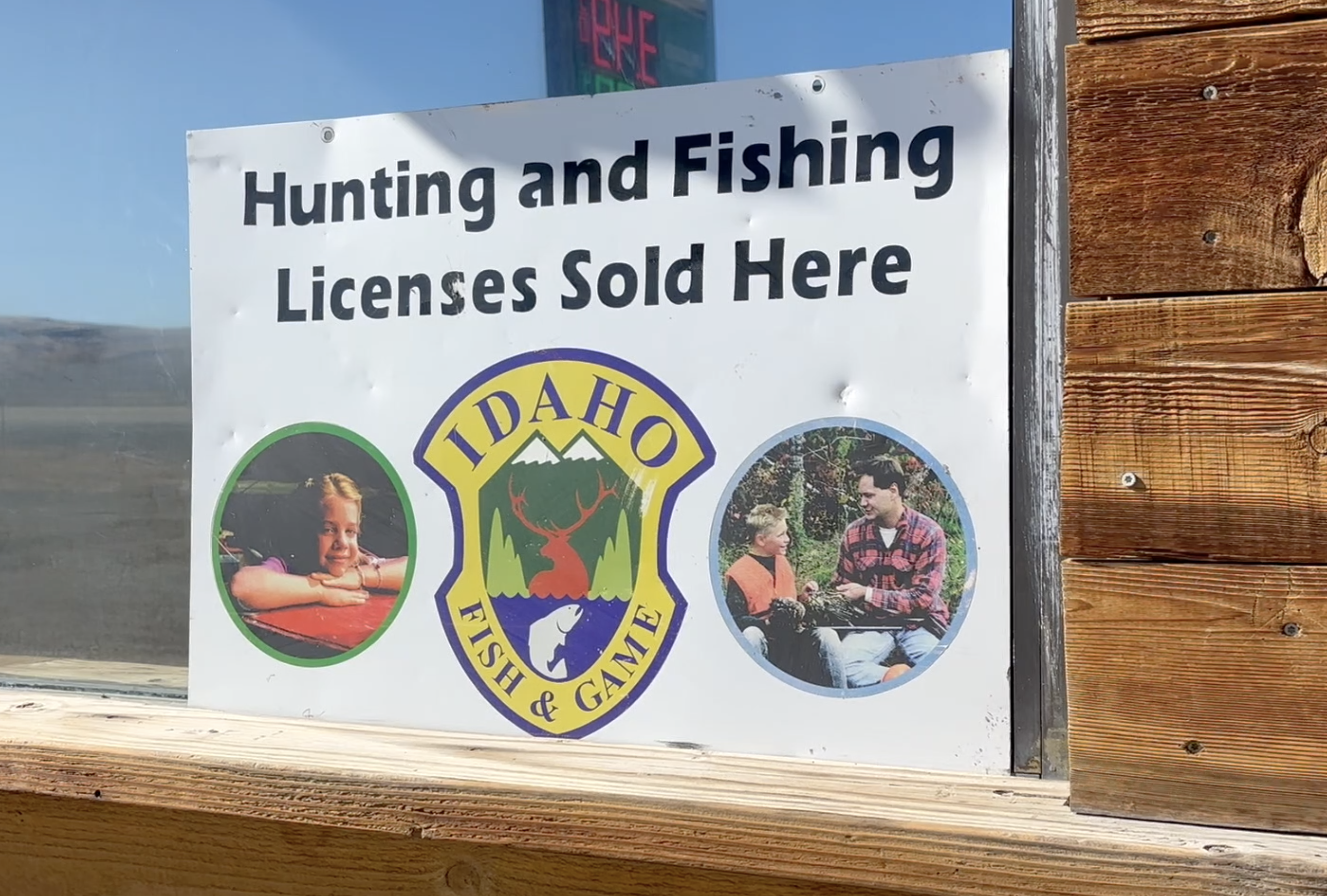 A sign in a window advertises hunting and fishing licenses sold here"