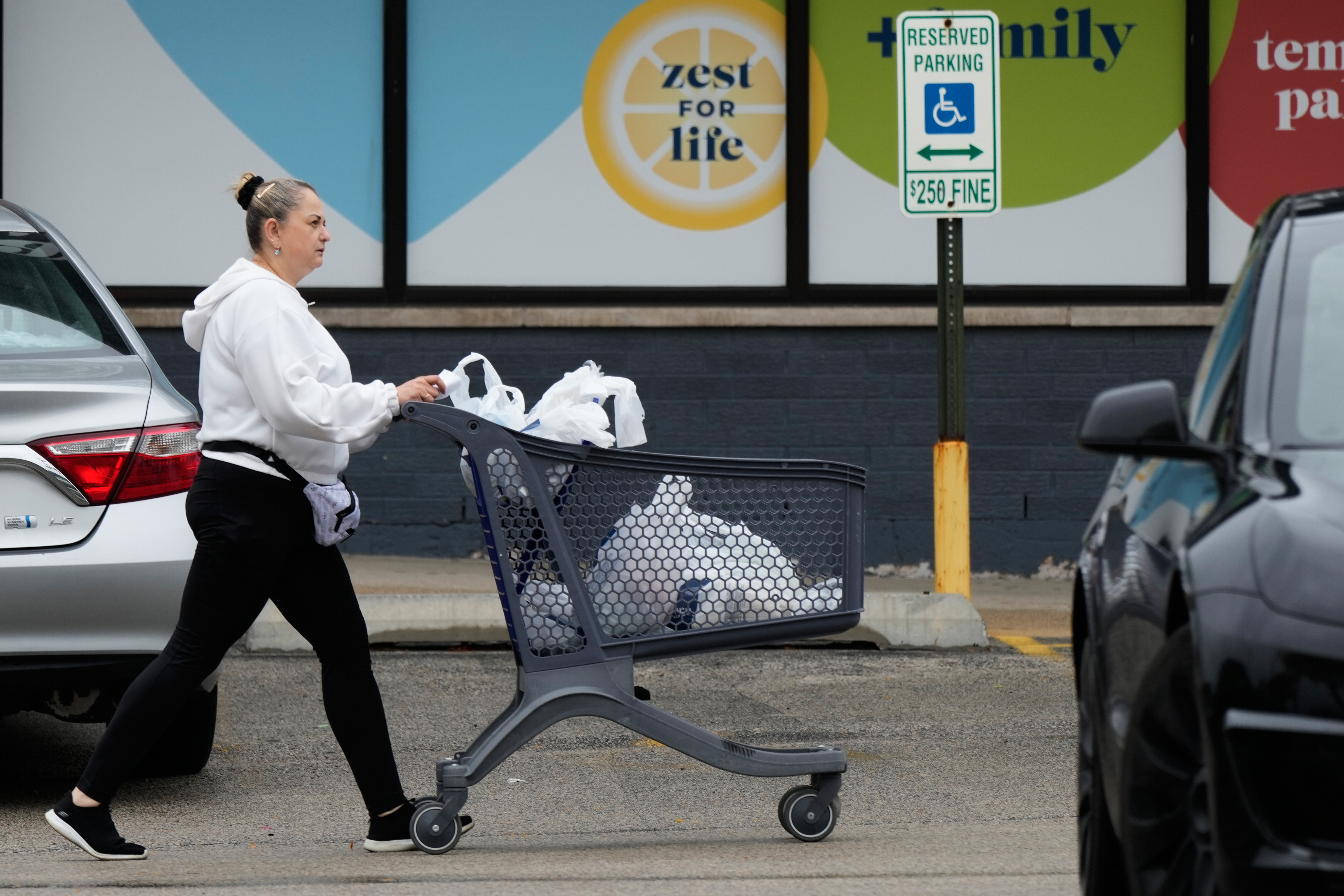 A woman pushes a shopping cart as she leaves a grocery store in Arlington Heights, Ill., Wednesday, Sept. 30, 2026. 
