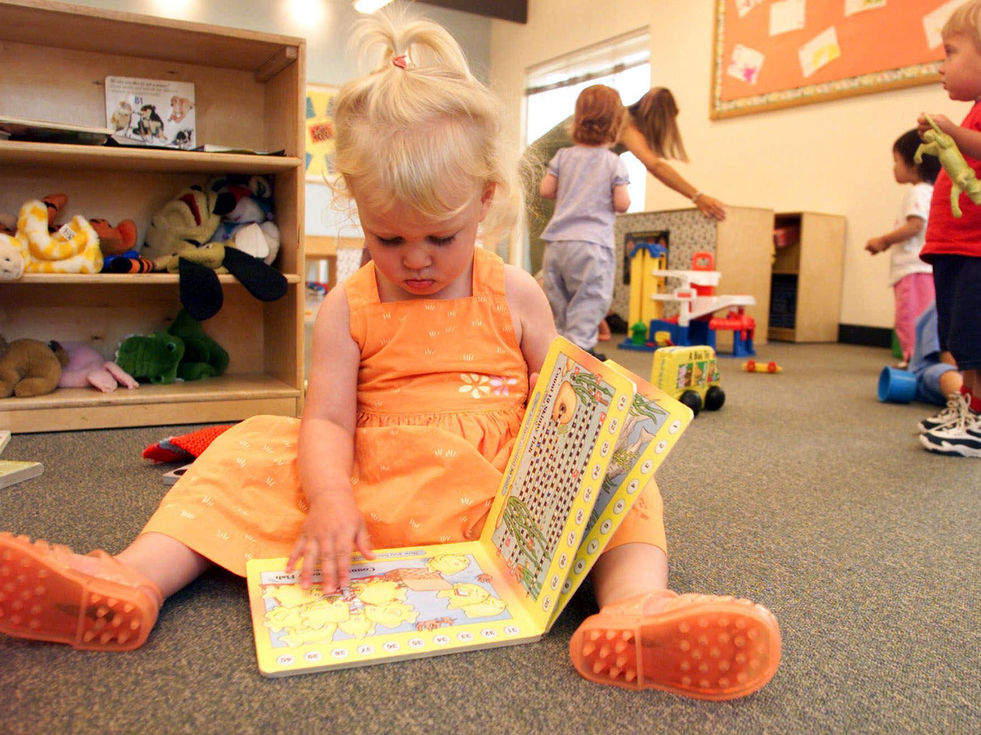 Child Reads a Book at Day Care Center