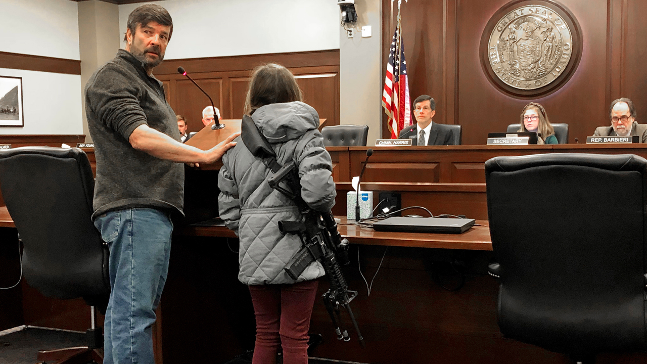 Charles Nielsen, 58, and his 11-year-old granddaughter, Bailey Nielsen, testify before a House panel at the Idaho Statehouse on Monday. Feb. 24, 2020 in Boise, Idaho. Visitors to Idaho 18 and older who can legally possess firearms would be allowed to carry a concealed handgun within city limits under legislation that headed to the House on Monday, Feb. 24. 