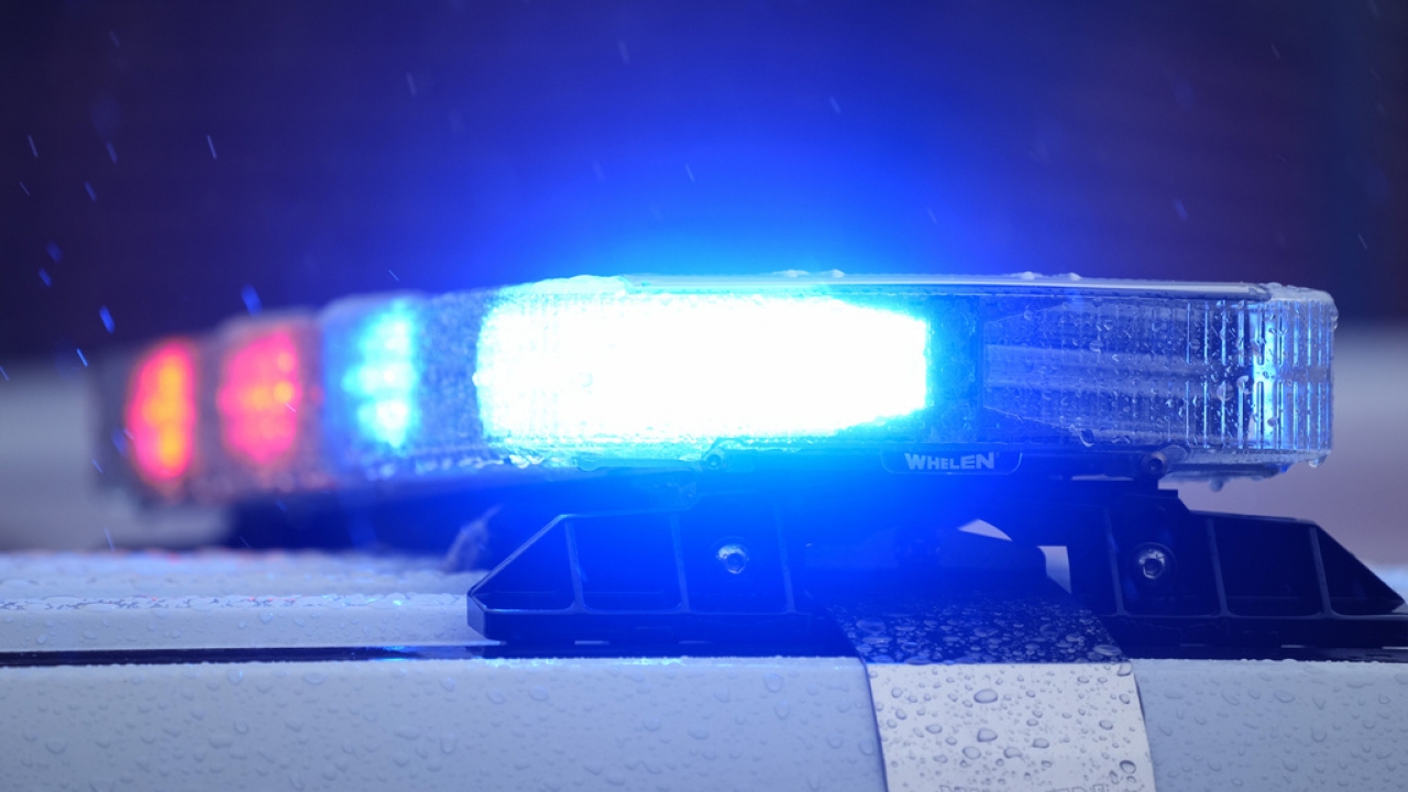 Lights on a parked police vehicle flash.