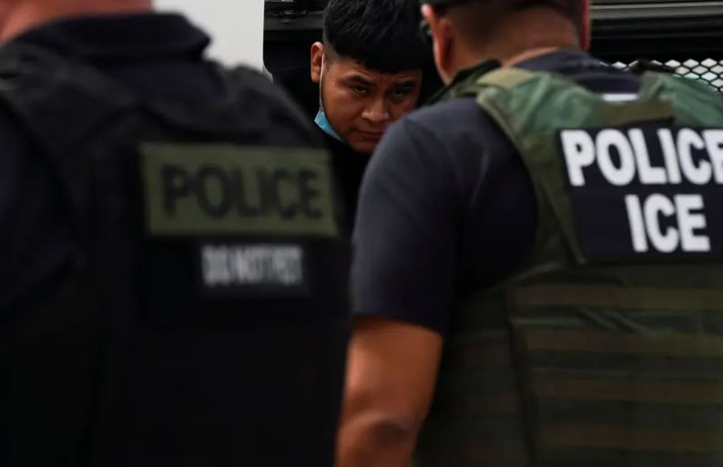 U.S. Immigration and Customs Enforcement agents escort detained migrants off a bus in Laredo on June 15, 2022. A bill approved by Texas lawmakers would compel most Texas sheriffs to enter agreements with ICE to enforce immigration laws.