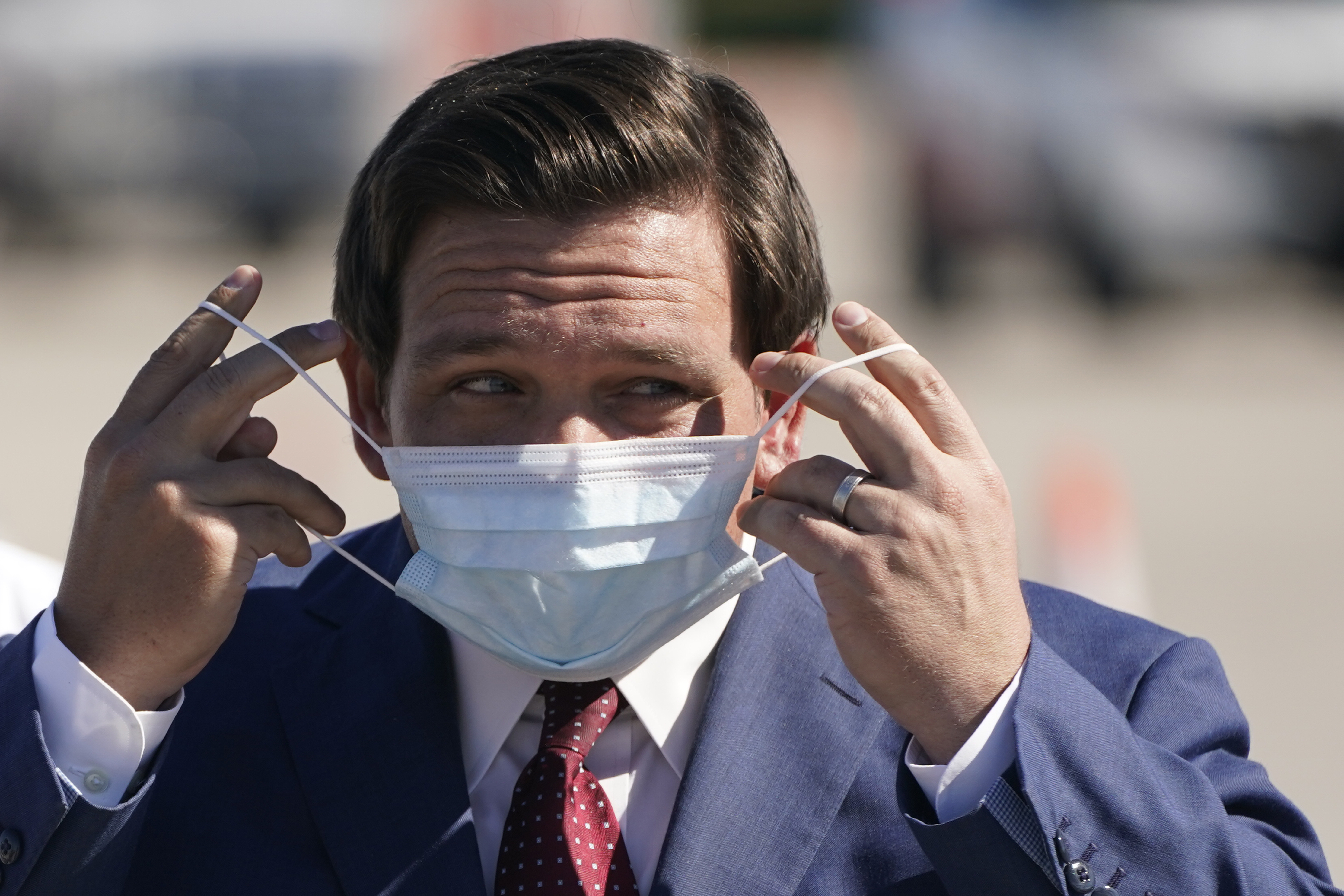 Gov. Ron DeSantis puts on mask at COVID-19 testing site at Hard Rock Stadium, Jan. 6, 2021