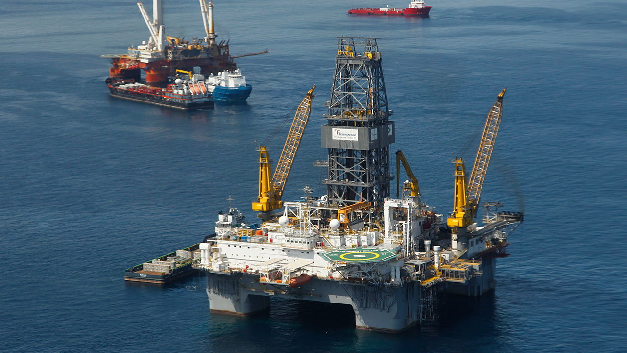 This file photo made Aug. 3, 2010, shows the Development Driller III, which is drilling the primary relief well, and the Helix Q4000, background left, the vessel being used to perform the static kill operation, at the site of the Deepwater Horizon Oil Spill in Gulf of Mexico, off the coast of Louisiana.  