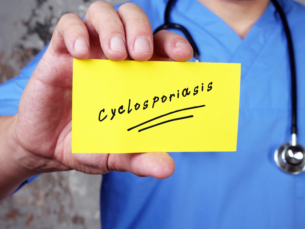 Cyclosporiasis on a sign held by a doctor