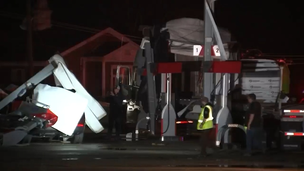 Debris covers vehicles and damaged a structure after a severe storm passed the area in Lake Village, Ind., late Tuesday, March 10, 2026.  