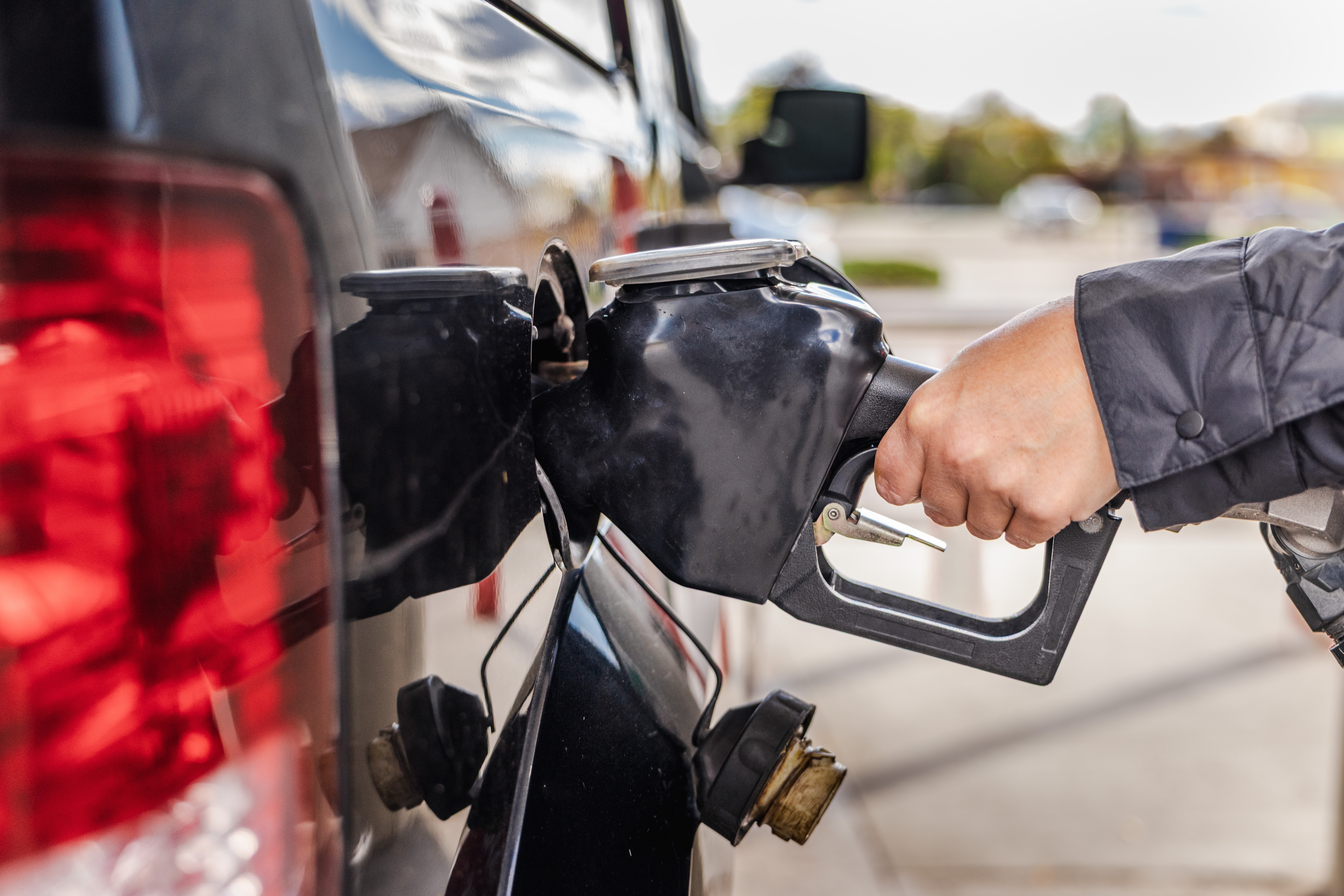 A person fills up their vehicle with gas.