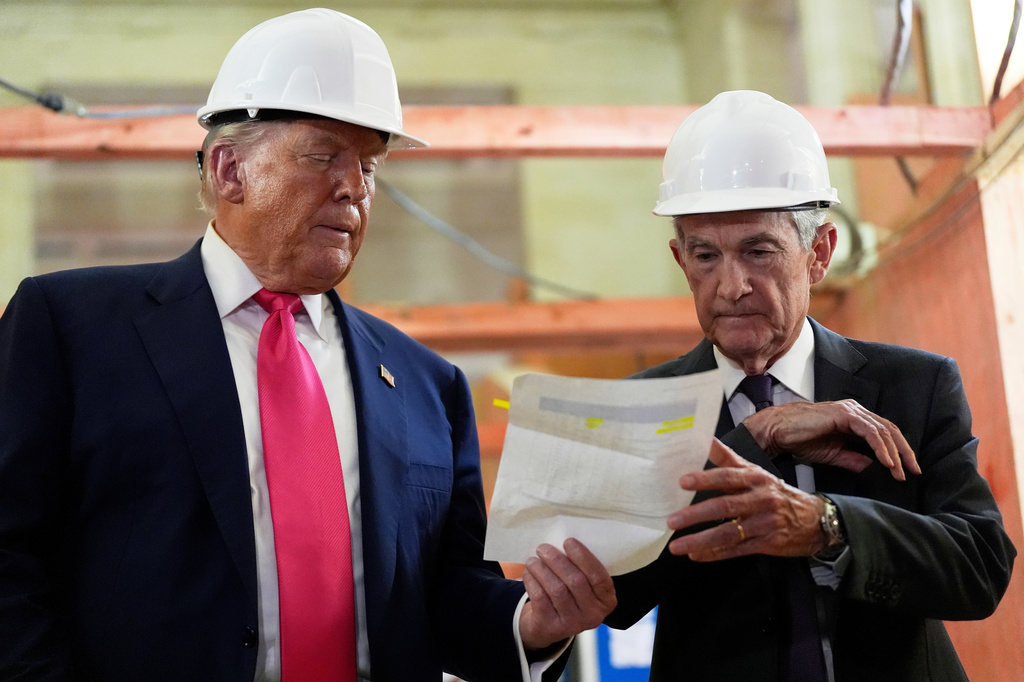 FILE - Federal Reserve Chairman Jerome Powell, right, and President Donald Trump look over a document of cost figures during a visit to the Federal Reserve, Thursday, July 24, 2025, in Washington. 