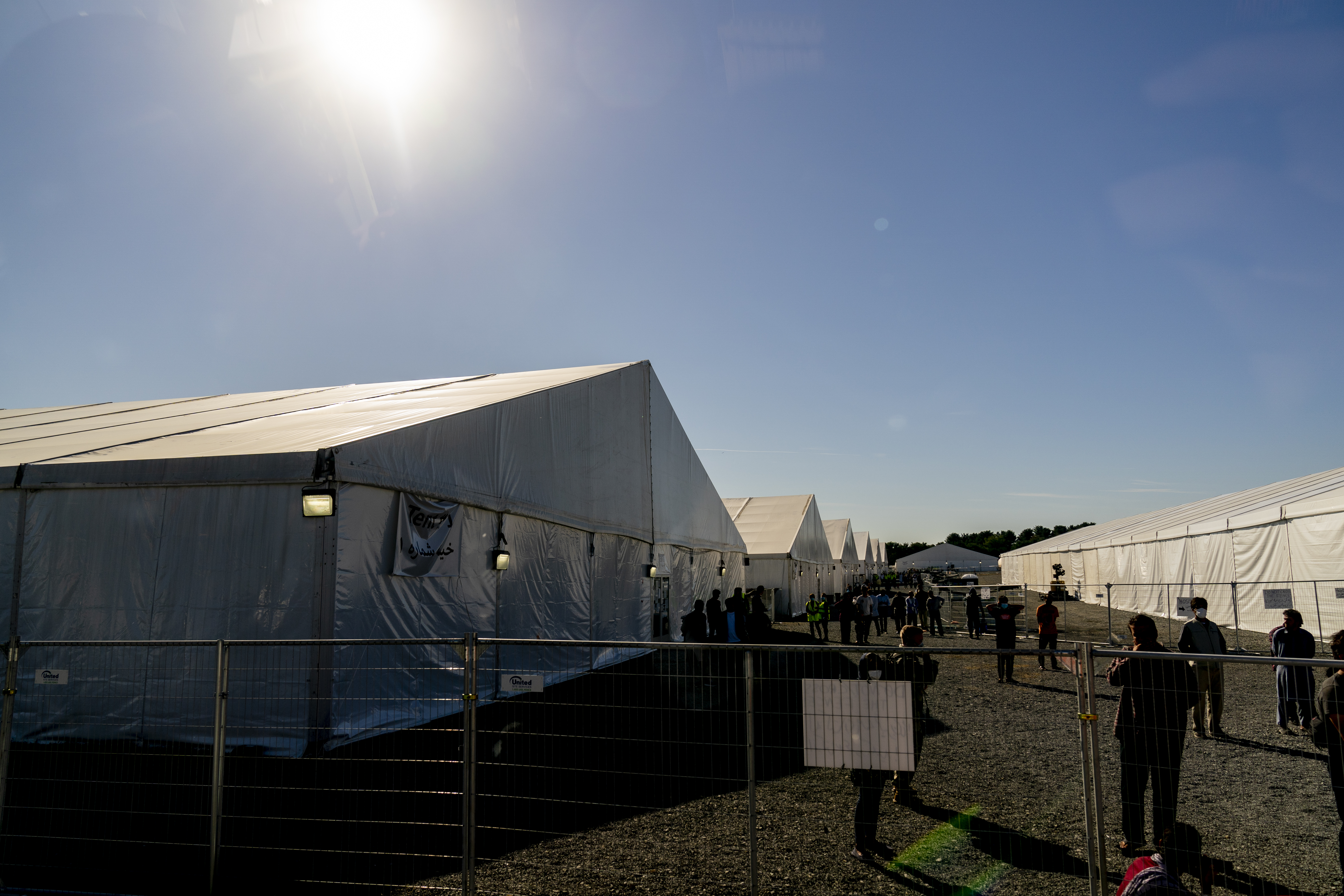 Afghan refugees walk through an Afghan refugee camp at Joint Base McGuire Dix Lakehurst, N.J., Monday, Sept. 27, 2021. 