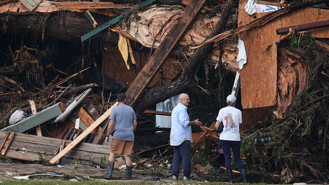 People look at debris on the banks of the Guadalupe River after a flash flood swept through the area Saturday, July 5, 2025, in Hunt, Texas.