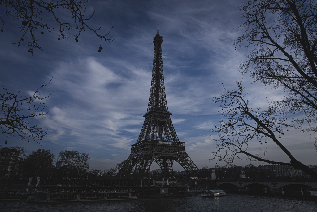 A boat makes it way along the Seine river, with the Eiffel Tower in the background, in Paris, France.