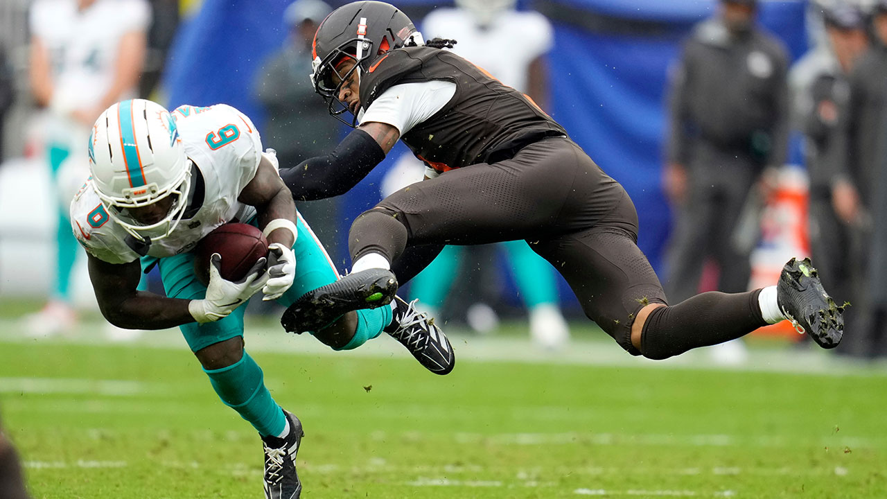 Miami Dolphins wide receiver Malik Washington (6) is hit by Cleveland Browns safety Rayshawn Jenkins in the second half of an NFL football game in Cleveland, Sunday, Oct. 19, 2025. 