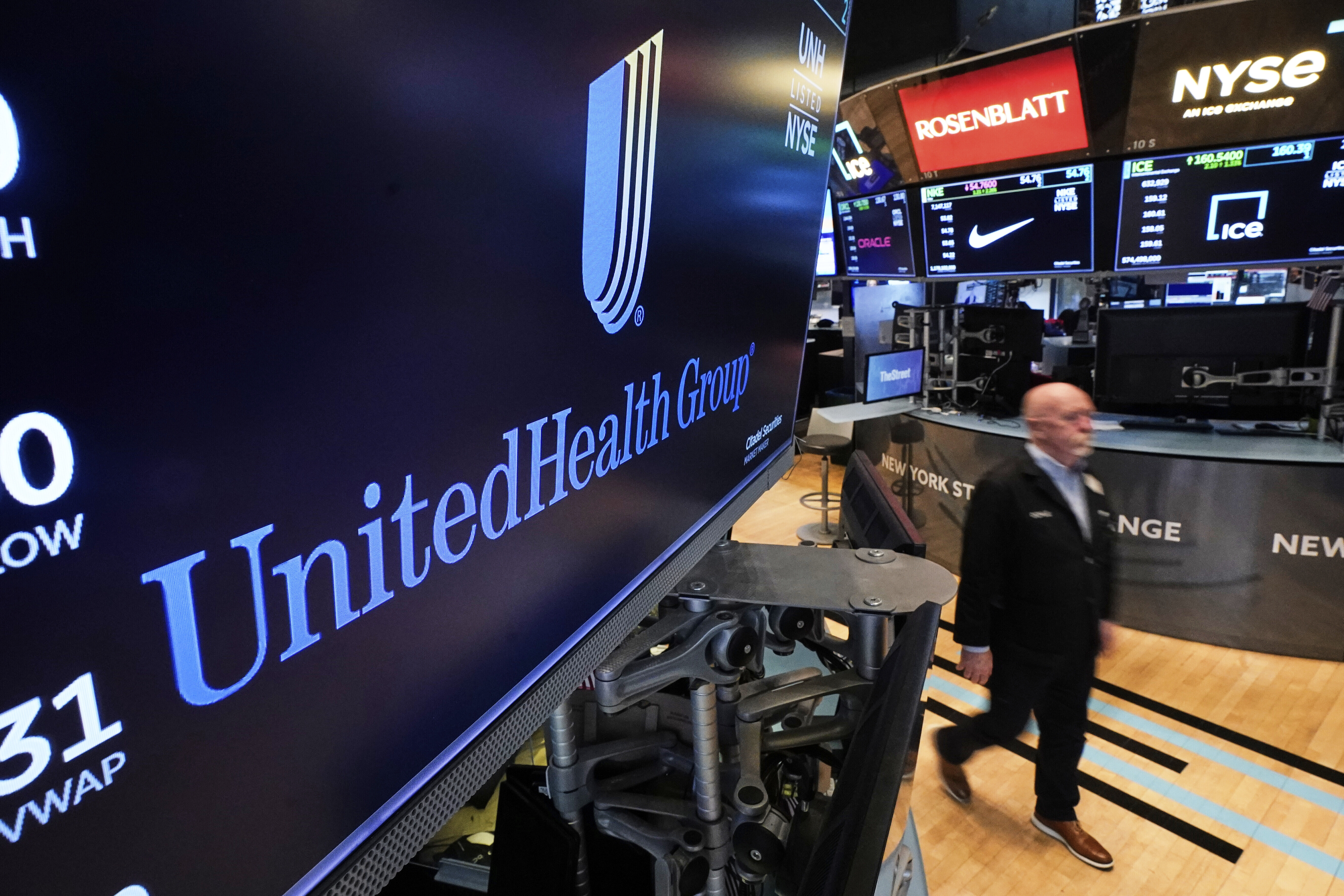 The logo for UnitedHealth Group appears above a trading post on the floor of the New York Stock Exchange, April 17, 2025.