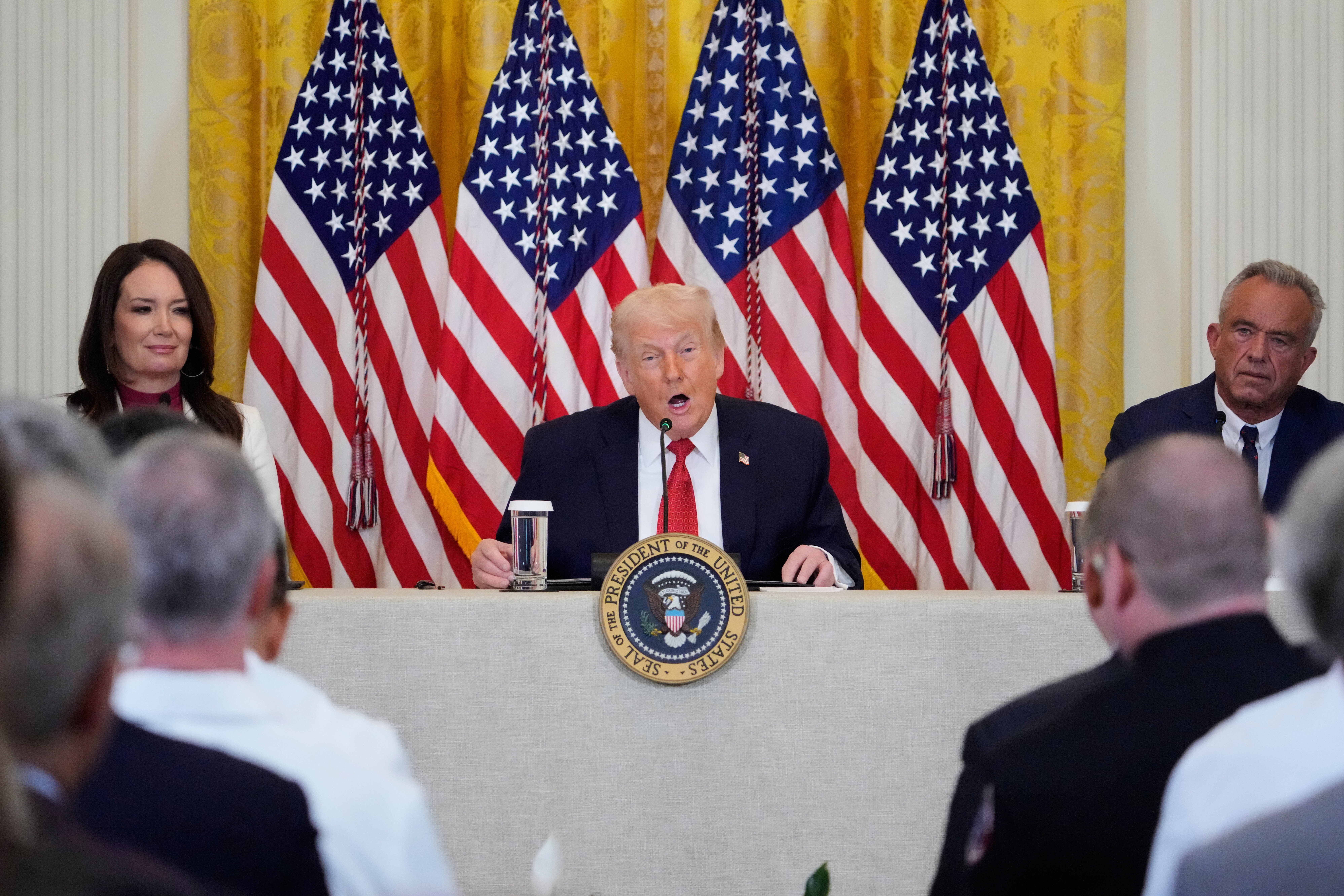 President Donald Trump, center, speaks during an event to promote investment in rural health care with Agriculture Secretary Brooke Rollins, left, and Health and Human Services Secretary Robert F. Kennedy Jr., right, in the East Room of the White House, Friday, Jan. 16, 2026, in Washington. 