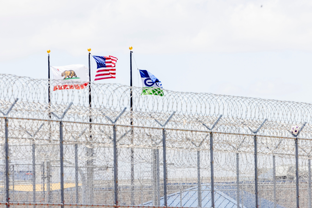 Flags from the U.S., California and GEO fly outside the Adelanto ICE Processing Center, Wednesday, May 27, 2026, in Adelanto, Calif. 