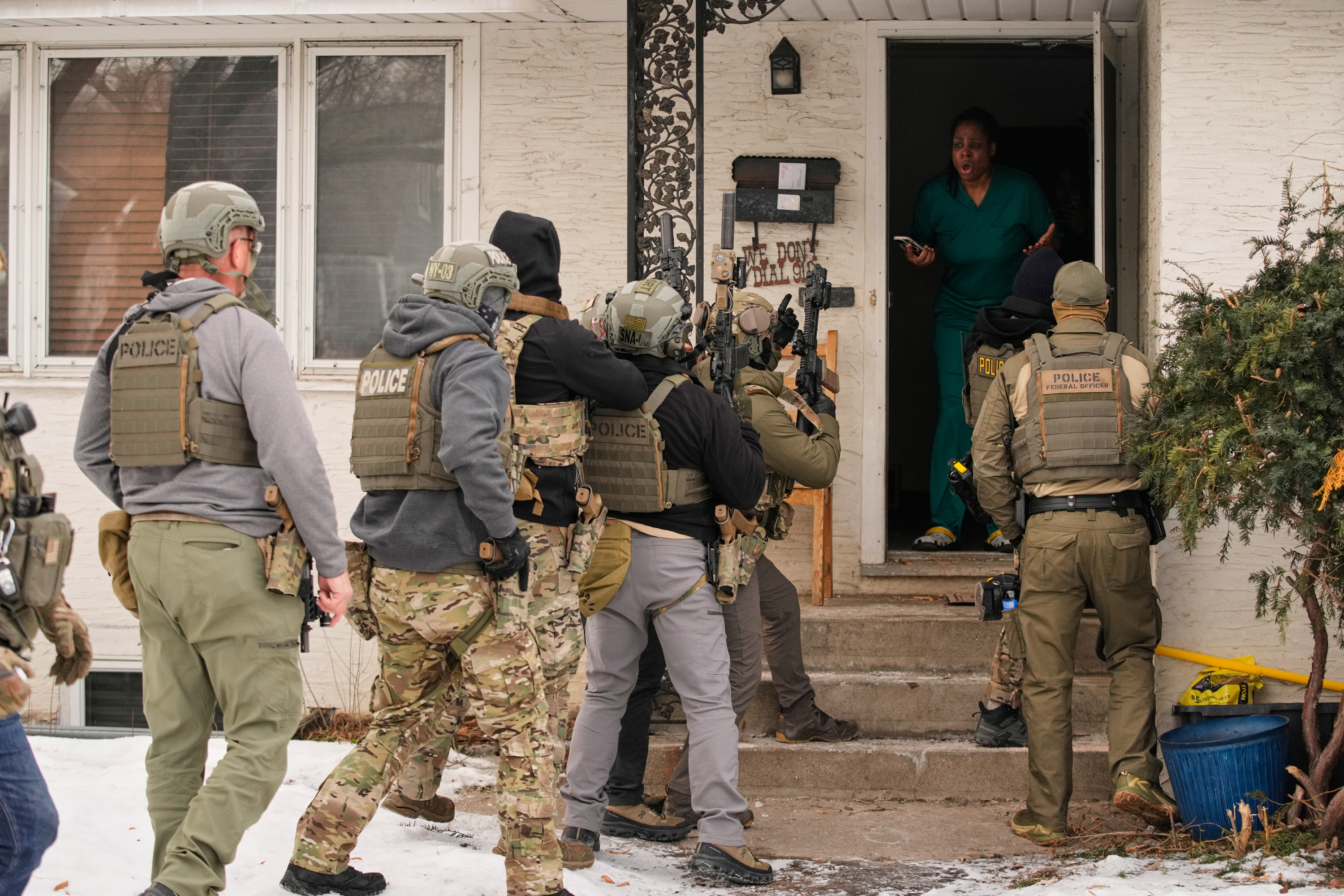 ADDS IDENTIFICATION: Teyana Gibson Brown, second from right, wife of Garrison Gibson, reacts after a federal immigration officer used a battering ram to break down a door before arresting Garrison Gibson, Sunday, Jan. 11, 2026, in Minneapolis. 