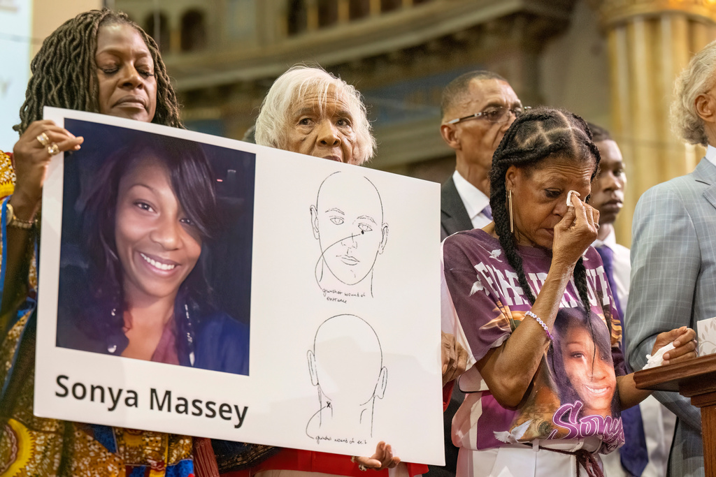 Donna Massey, center right, wipes tears from her face as she listens to Rev. Al Sharpton, right, speak during a press conference over the shooting death of her daughter, Sonya, who was killed by Illinois sheriff's deputy Sean Grayson, at New Mount Pilgrim Church in Chicago, July 30, 2024.