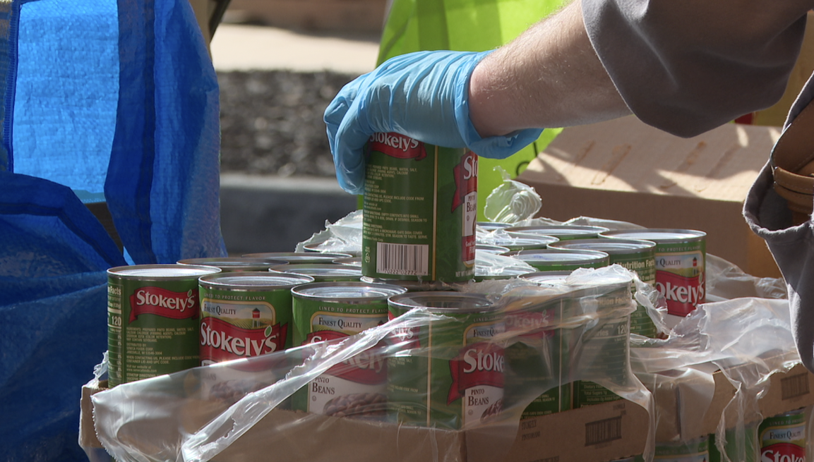 Volunteers passing out canned goods. 