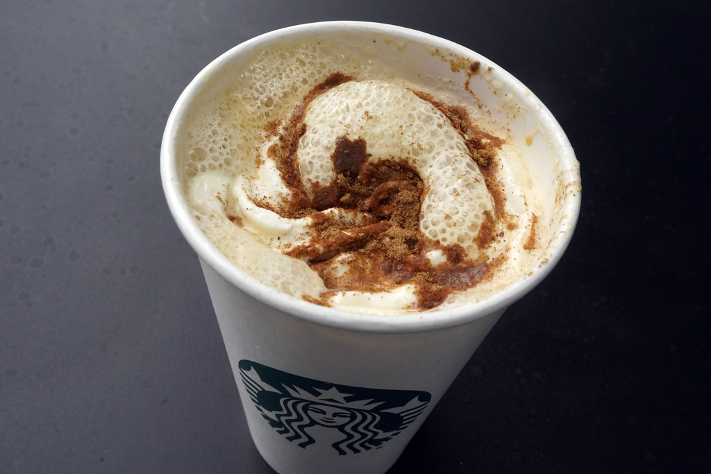 A Pumpkin Spice Latte drink rests on a table at a Starbucks.