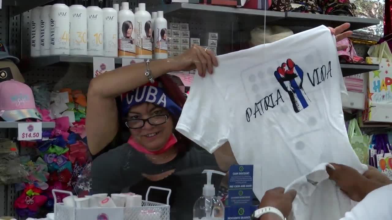 Woman holds up 'Patria y Vida' shirt at La Cuevita Clothing Store in West Palm Beach