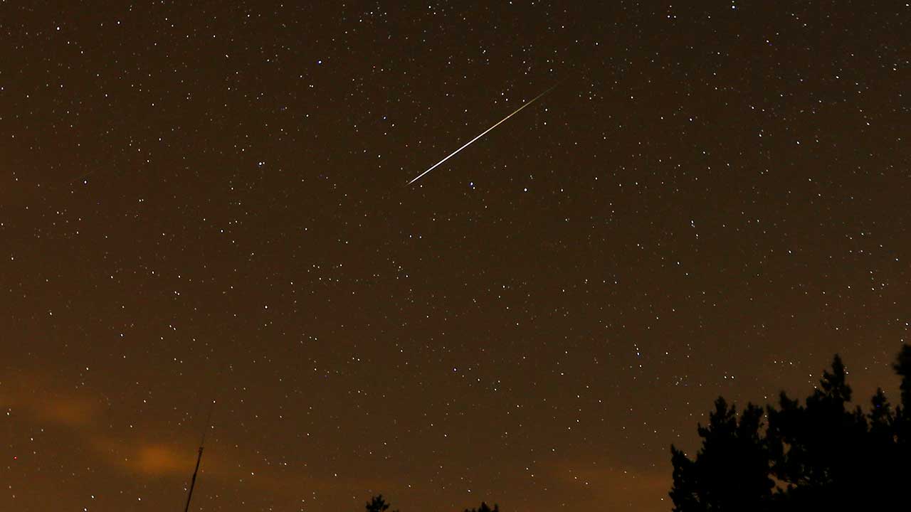 FILE - In this long exposure photo, a streak appears in the sky during the annual Perseid meteor shower at the Guadarrama mountains, near Madrid, in the early hours of Aug. 12, 2016.