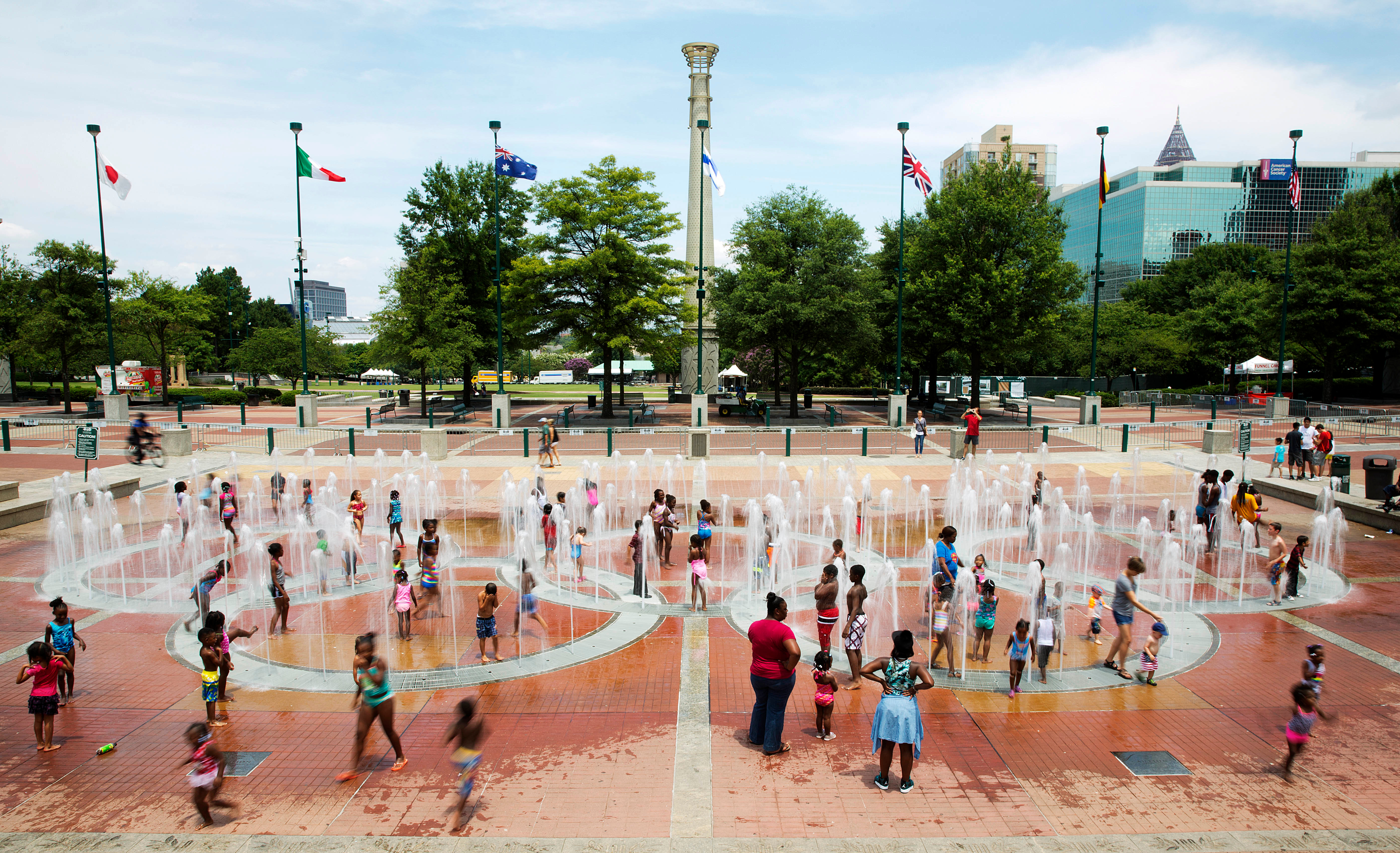 FILE - In this Friday, July 22, 2016 photo, people play in the fountains shaped by the Olympic rings at Centennial Olympic Park in Atlanta.  