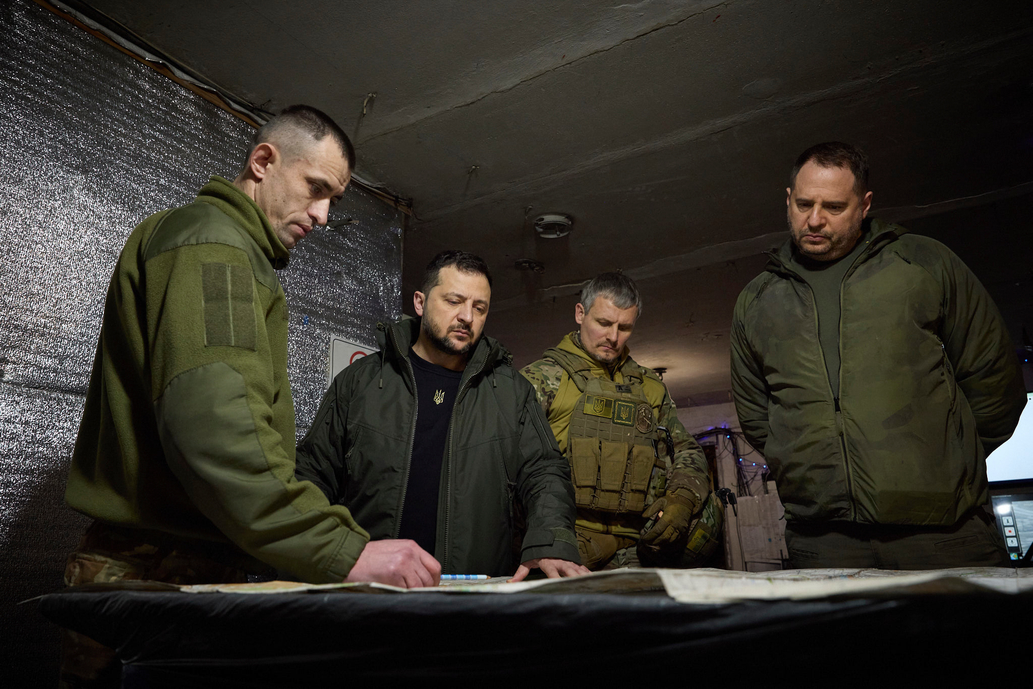 In this photo provided by the Ukrainian Presidential Press Office, Ukrainian President Volodymyr Zelenskyy, 2nd left, looks at a map during his visit to Ukrainian 110th mechanised brigade in Avdiivka, the site of fierce battles with the Russian troops in the Donetsk region, Ukraine, Friday, Dec. 29, 2023. Right is head of the Presidential Office Andriy Yermak; deputy head of the Presidential Office Roman Mashovets is 2nd right. 