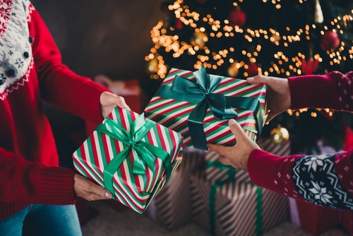 Stock image of people exchanging Christmas gifts.