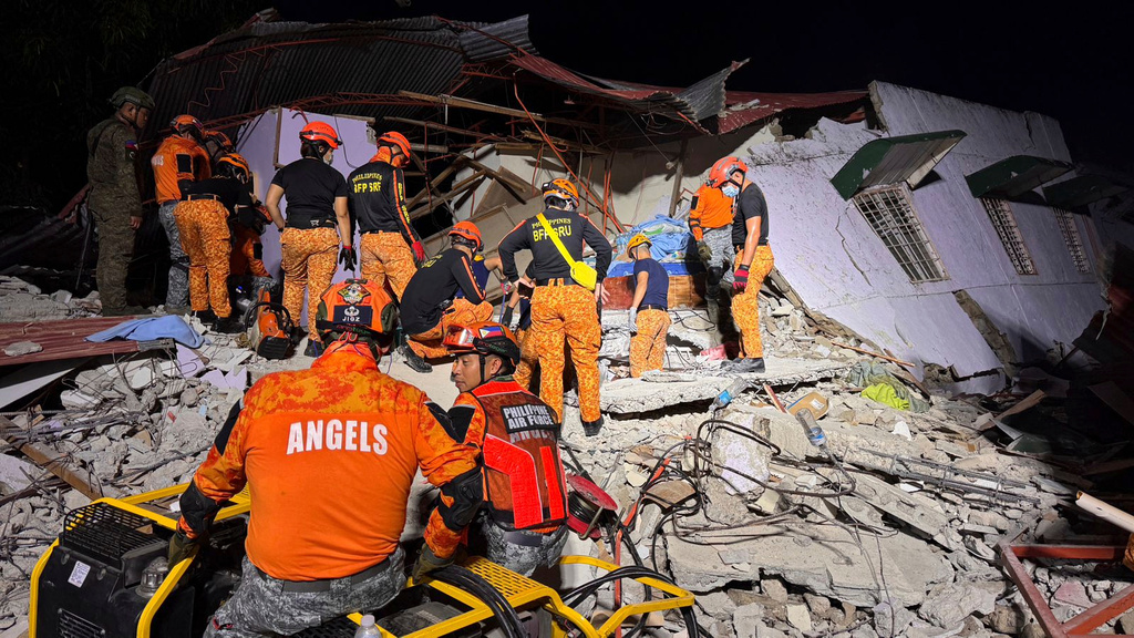 Rescuers search for survivors underneath rubble in Bogo, Philippines.