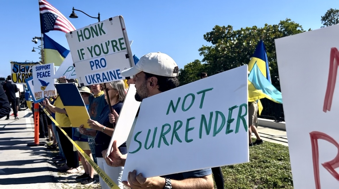 As discussions on the war in Ukraine took place at Mar-a-Lago on Dec. 28, 2025, just yards away, crowds lined the Southern Boulevard Bridge, calling for peace.