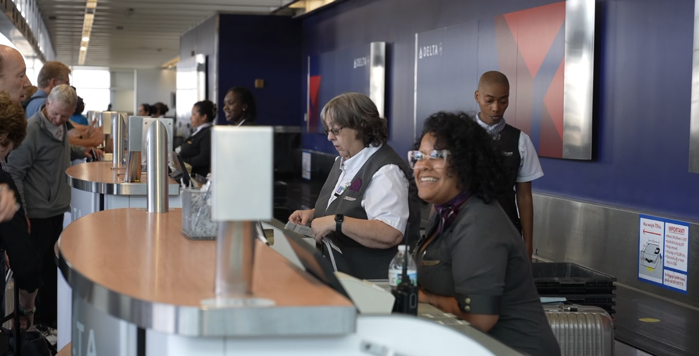 Delta workers greet travelers. 