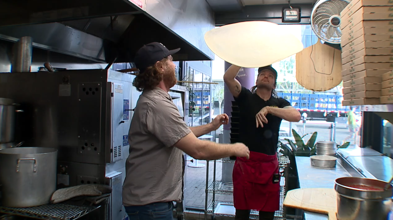 TnT pizza owners throwing dough