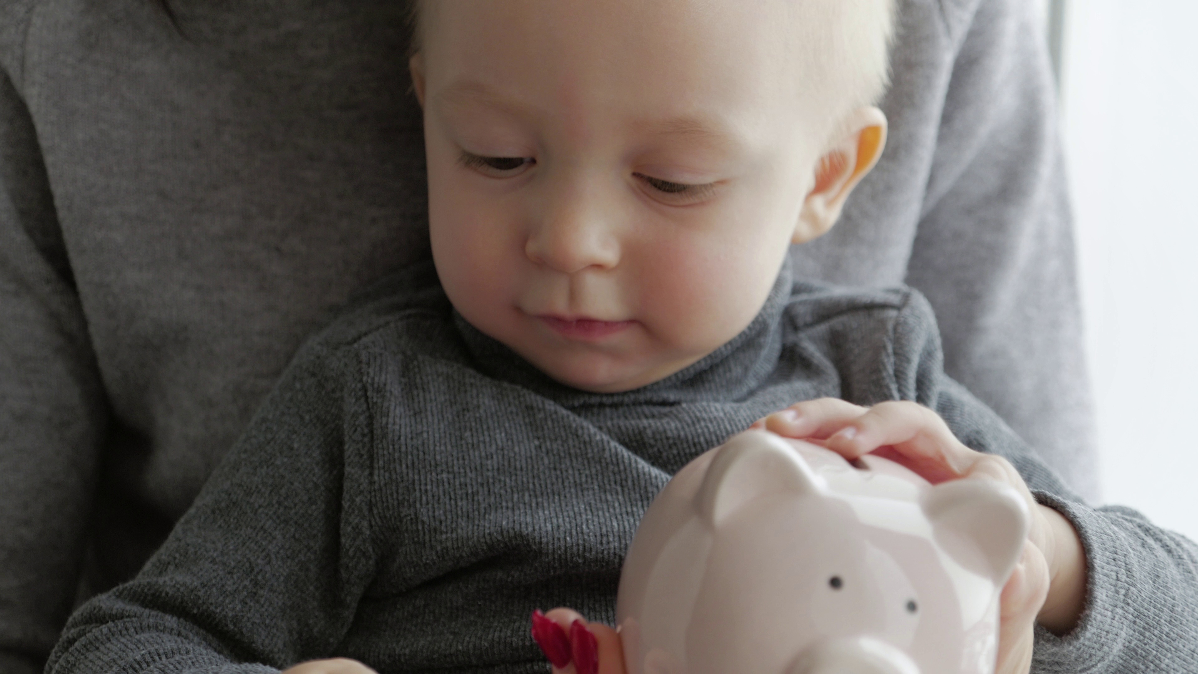 mother-and-little-son-putting-coins-into-piggy-bank-for-the-future-savings-SBI-349460680.jpg