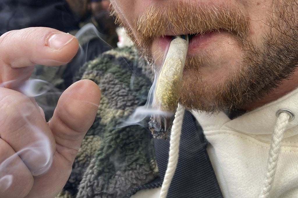  A man smokes marijuana in lower Manhattan outside the first legal dispensary for recreational marijuana in New York on Thursday, Dec. 29, 2022. 