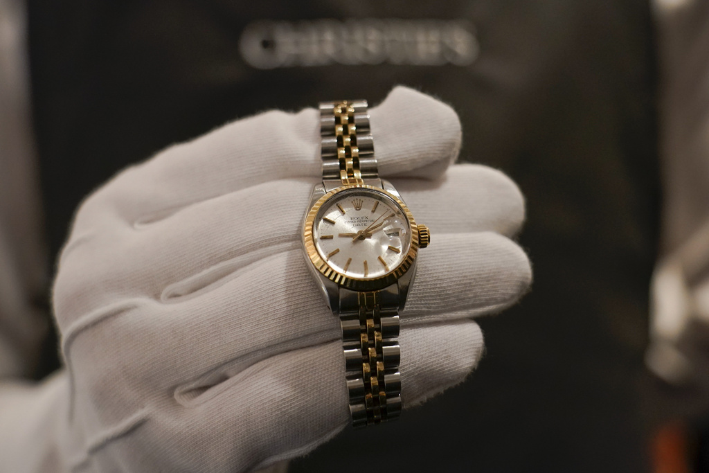 A member of staff holds a Rolex watch, as part of The Pattie Boyd Collection at Christie's, in London, Thursday, March 14, 2024. 