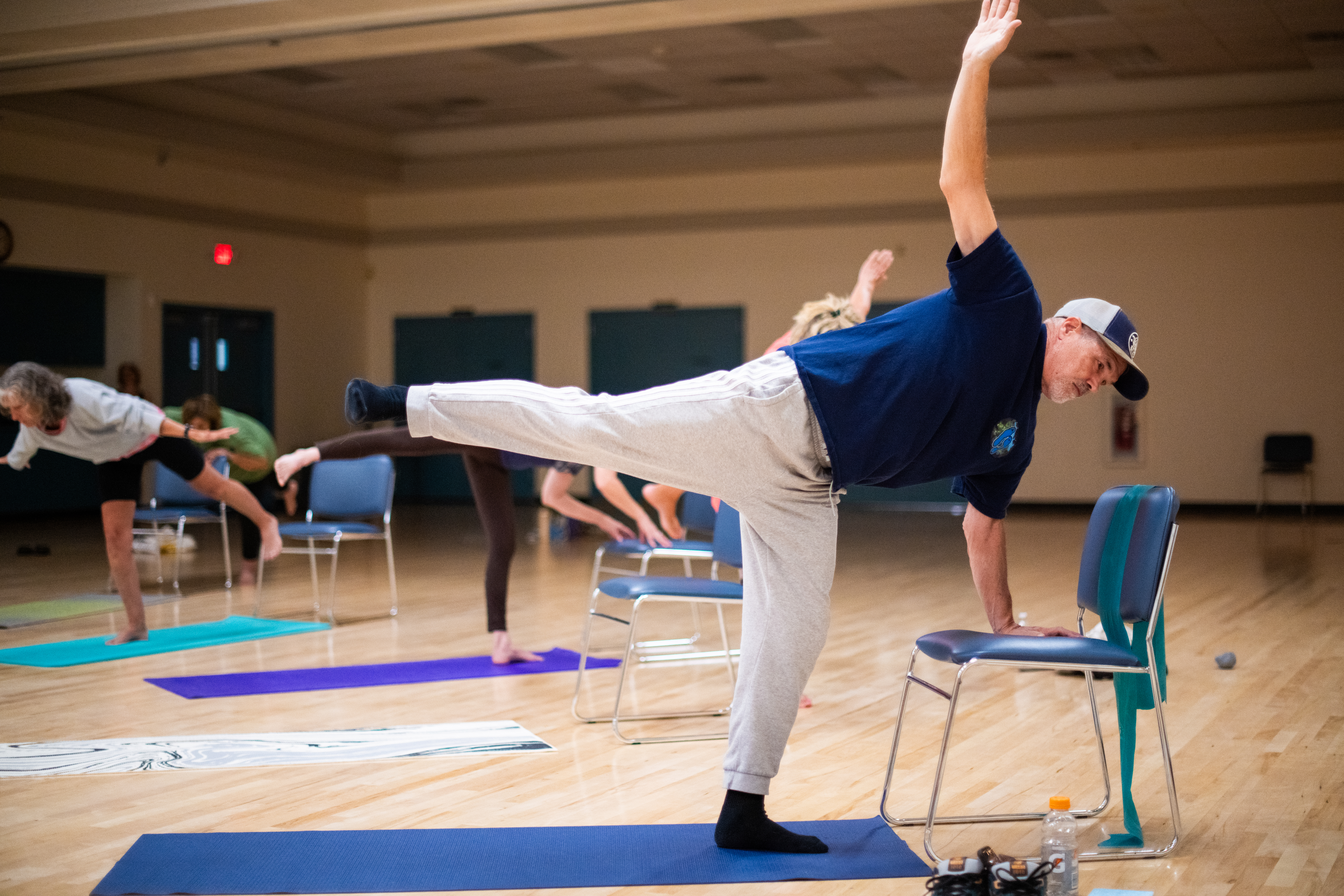 Man doing yoga pose with chair