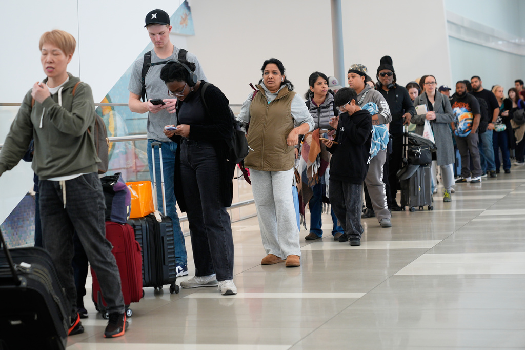 Travelers wait in a lines to get through security at LaGuardia Airport in New York, Monday, March 30, 2026.