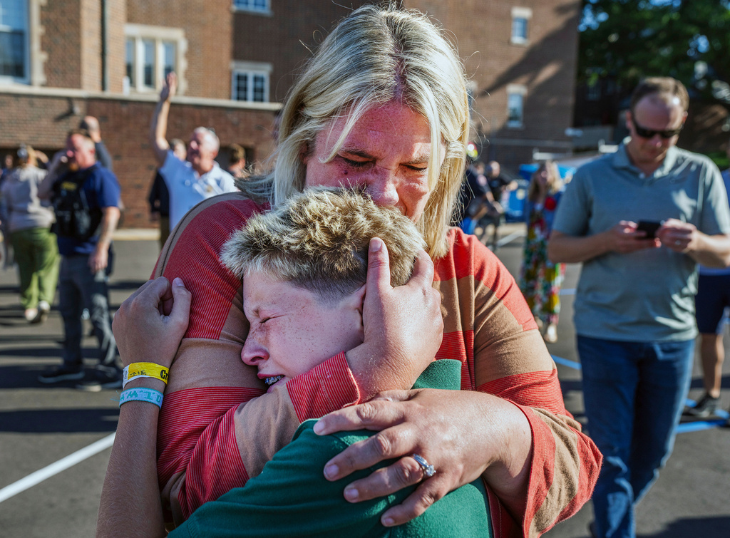 A parent hugs her son during an active shooter situation at the Annunciation Church in Minneapolis, Minn.