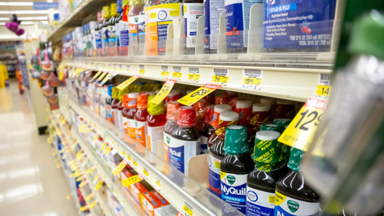 A view of several cold and flu medicine products, on display at a grocery store.