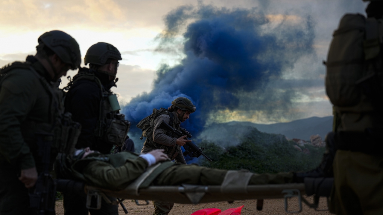 Israeli soldiers carry a stretcher toward a military helicopter during a training exercise.
