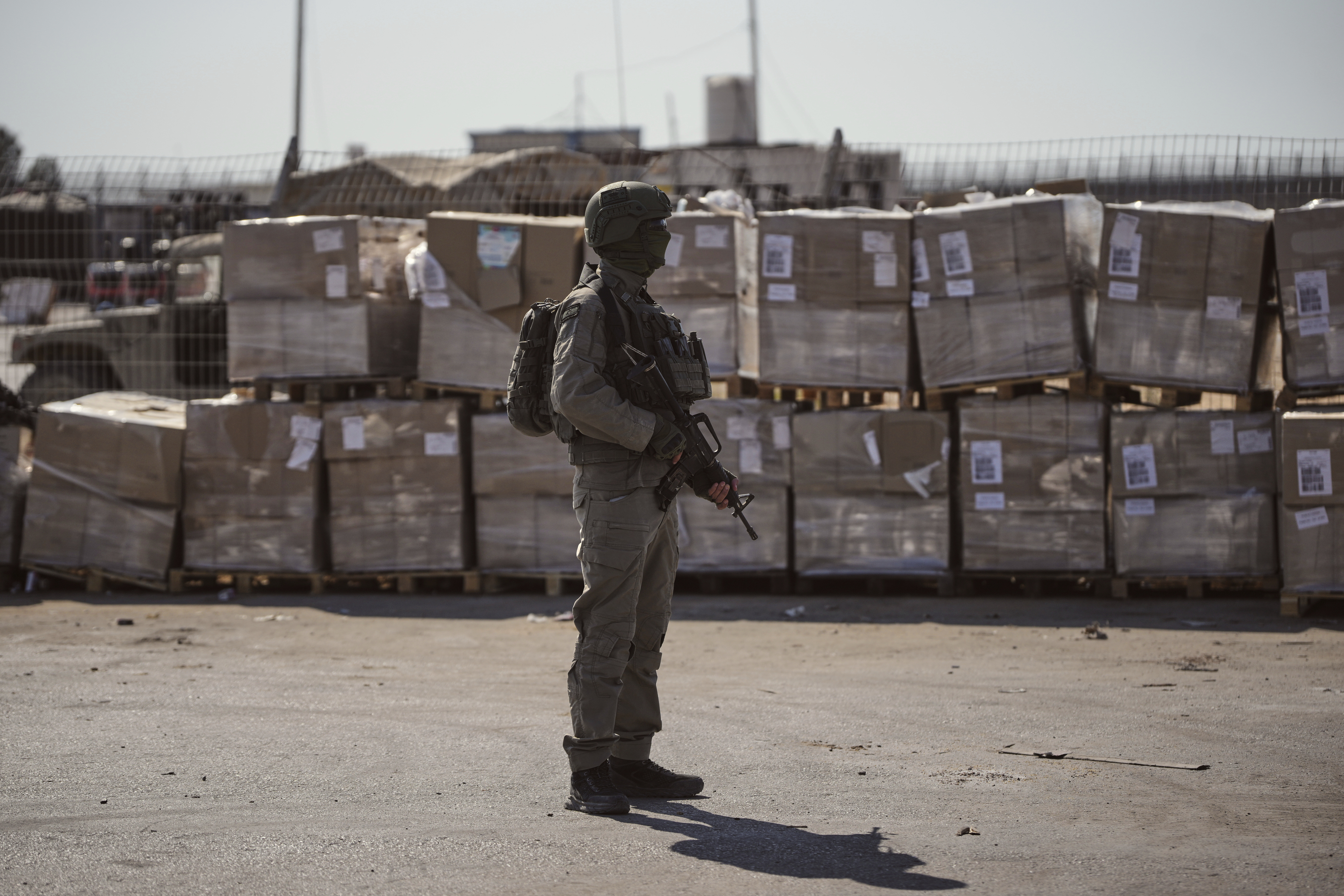  An Israeli soldier stands beside humanitarian aid packages awaiting pickup on the Palestinian side of the Kerem Shalom crossing in the Gaza Strip, Thursday, July 24, 2025, during a media tour organized by the Israeli army. 